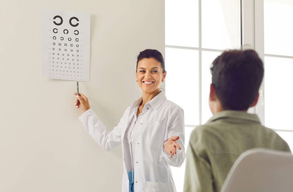 An eye doctor tests a young patient's eyesight with the Landolt C eye chart