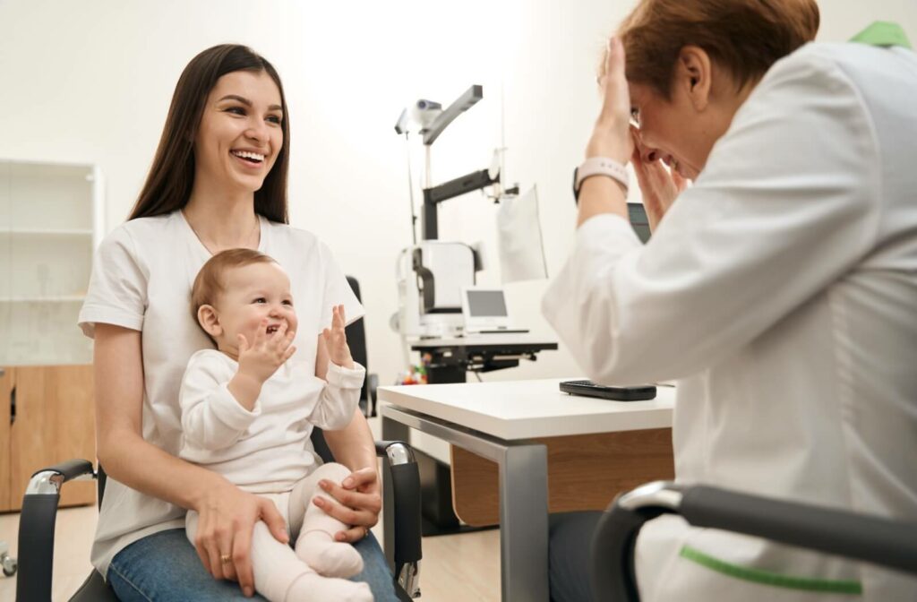 Cheerful young family of two sitting at eye doctor appointment for cross-eyed baby