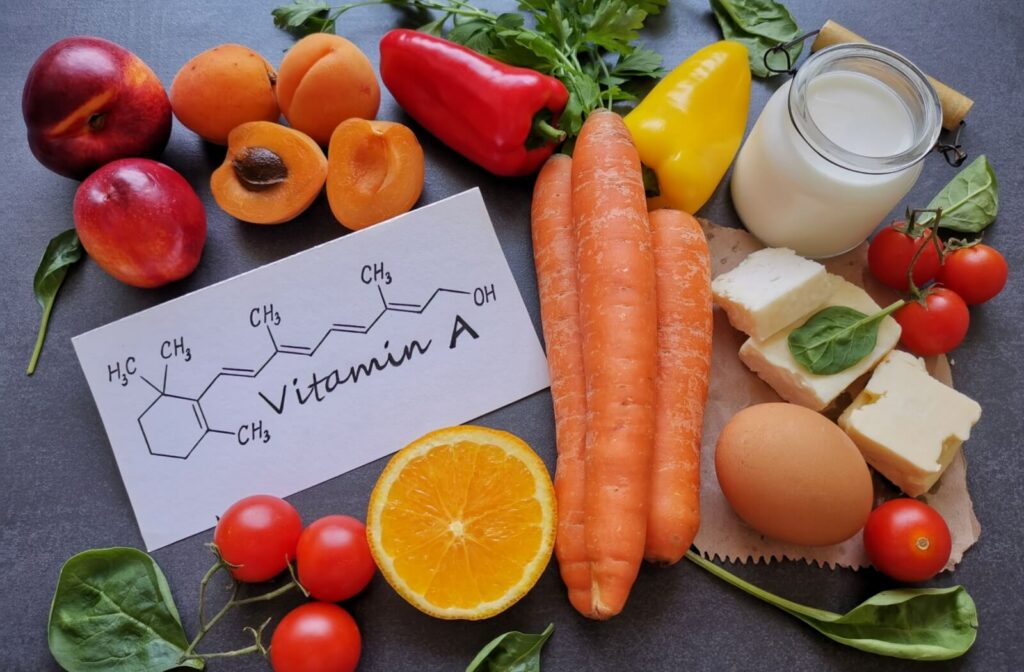 A top view of various colorful foods rich in Vitamin A on a table.