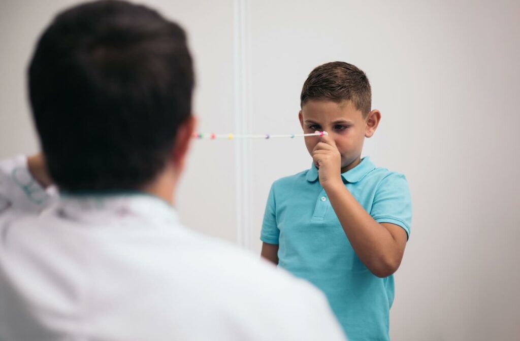 A vision therapist guides a child through eye exercises using a focusing string.