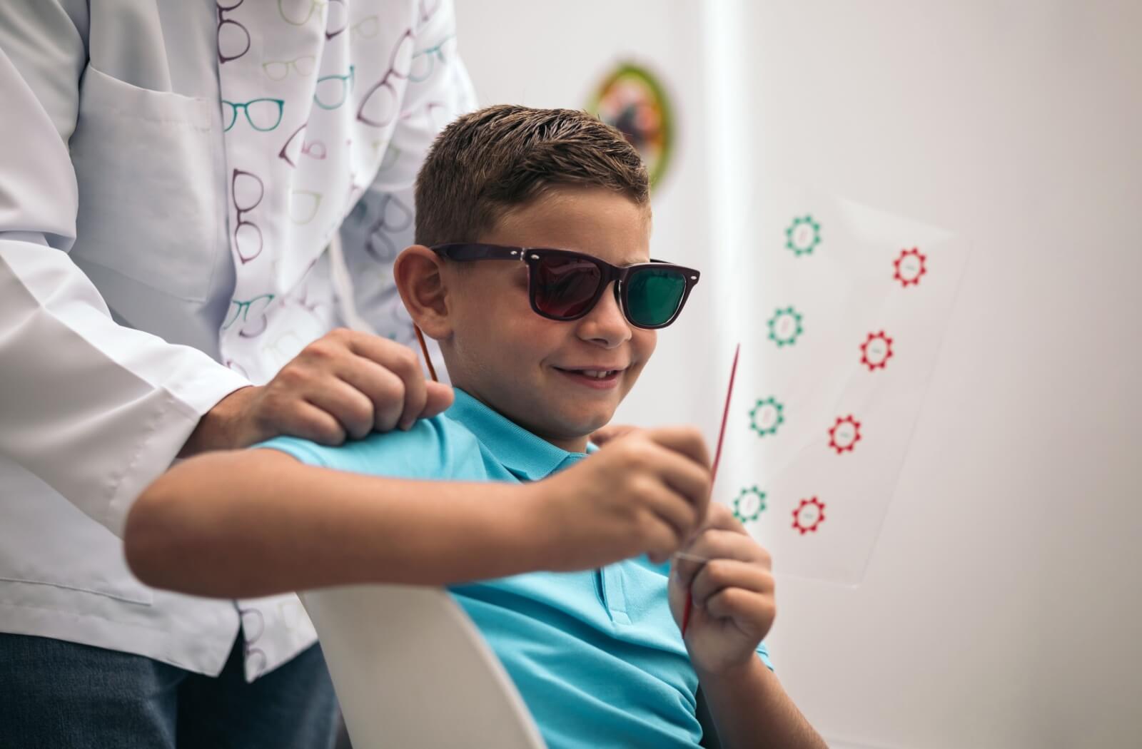 A child completes a vision therapy exercise under the guidance of their eye doctor.