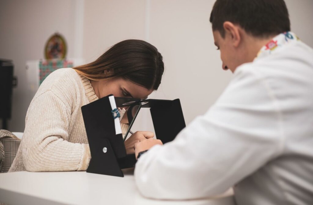 A young adult performs vision therapy exercises with their eye doctor.