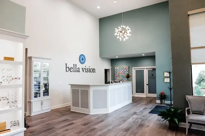 Bright, modern optometry office interior with eyewear displays, consultation tables, chairs, and a reception area.